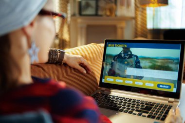 genç hipster dizüstü bilgisayarda online otobüs biletleri satın alma