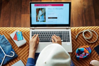 dizüstü bilgisayarda online alışveriş yaparken giysi sipariş genç kadın