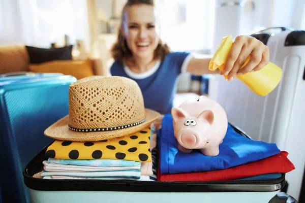 Closeup on traveller woman applying sunscreen on piggy bank — Stock Photo, Image