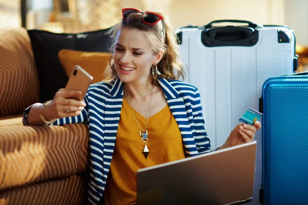Mujer sonriente con boletos de reserva de tarjeta de crédito y teléfono inteligente — Foto de Stock