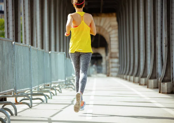 パリジョギングのポン・ド・ビル・ハケイム橋のスポーツウーマン — ストック写真