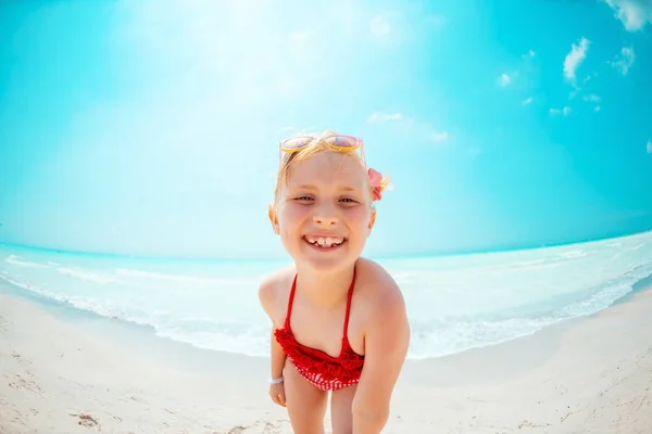 Retrato de criança moderna sorridente em roupa de praia vermelha no litoral — Fotografia de Stock