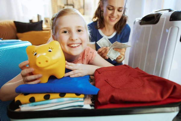 Mãe feliz e filha com o banco porquinho ter viagem de orçamento — Fotografia de Stock