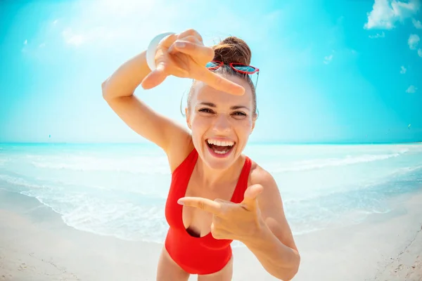 Happy young woman framing with hands on seacoast — Stock Photo, Image