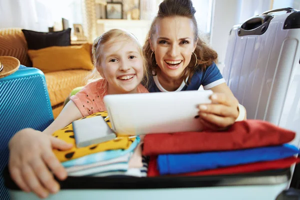 Leende mor och dotter turister köper flyg online — Stockfoto