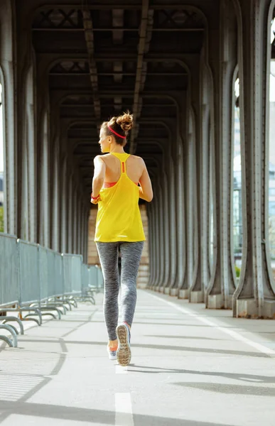 Kobieta sportowa na mostu Pont de Bir-Hakeim w Paryżu jogging — Zdjęcie stockowe