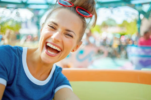 Felice viaggiatore moderno donna nel parco a tema avendo cavalcare — Foto Stock