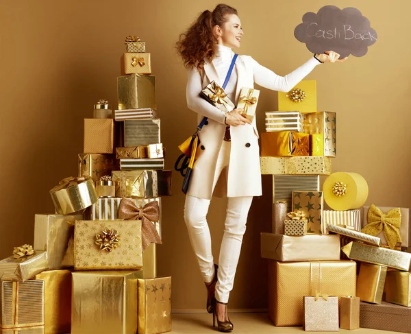 Fashion-monger with present boxes looking at CashBack sign — Stock Photo, Image