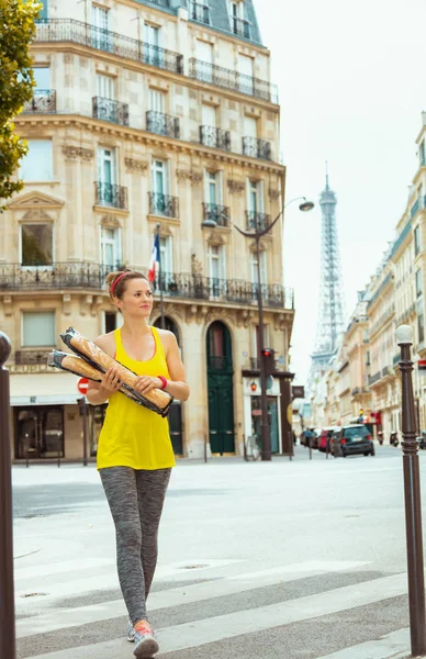 Mujer activa con 2 baguettes franceses cruzando la calle — Foto de Stock