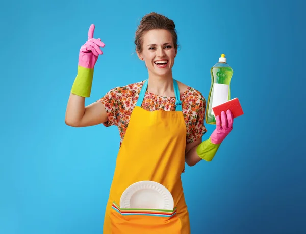 Dona de casa com esponja e líquido de lavar louça tem ideia em azul — Fotografia de Stock