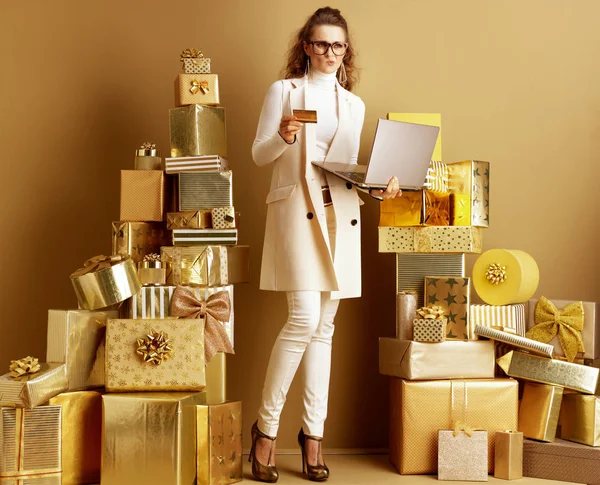Mulher comprador com laptop dourado e cartão de crédito fazendo on-line s — Fotografia de Stock
