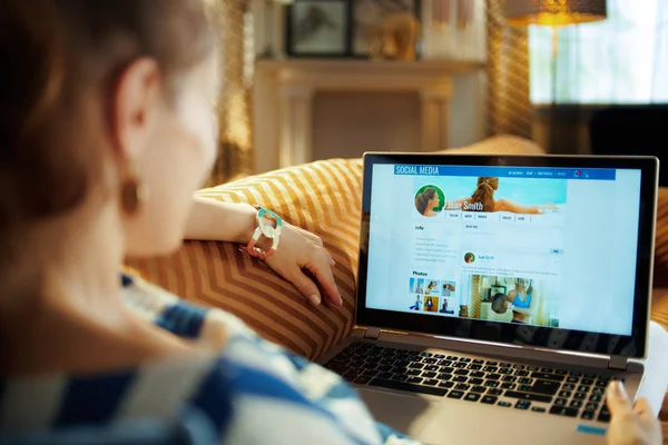 Modern hemmafru tittar på sociala medier på laptop — Stockfoto