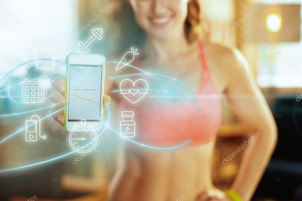 Closeup on phone screen with fit app in hand of healthy woman