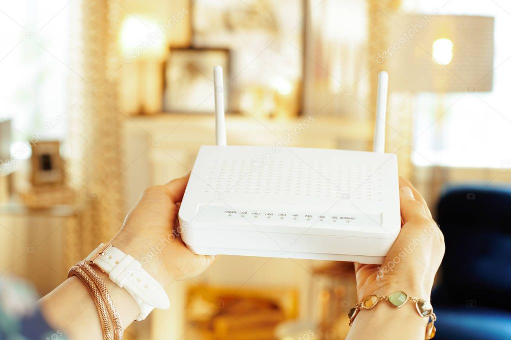 Closeup on modern wifi router with 2 antennas in hand of woman