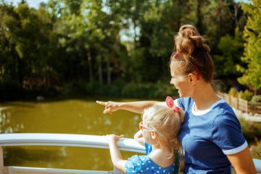 mother and child exploring countryside while having river voyage clipart