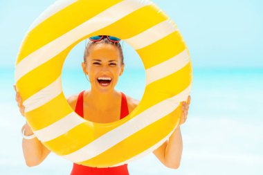 deniz kıyısında kadın sarı şişme lifebuoy bakarak