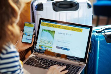 dizüstü bilgisayar ve akıllı telefon otel rezervasyon genç turist kadın