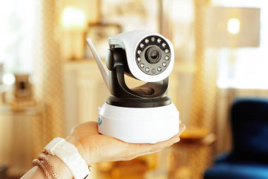 Modern kadının elinde wifi güvenlik kamerası closeup