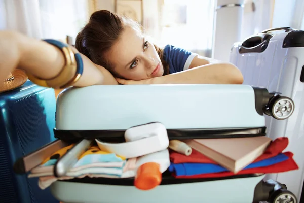 Stressed stylish tourist woman relaxing on over packed suitcase — Stock Photo, Image