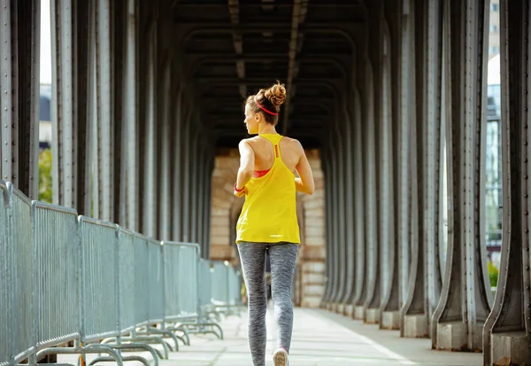 Sportvrouw op de Pont de Bir-Hakeim-brug in Parijs running — Stockfoto