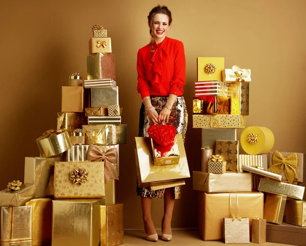 Donna elegante e sorridente con borse della spesa e cuore rosso — Foto Stock