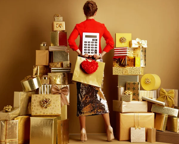 Žena s nákupními pytli, červeným srdcem a velkou bílou kalkulačkou — Stock fotografie