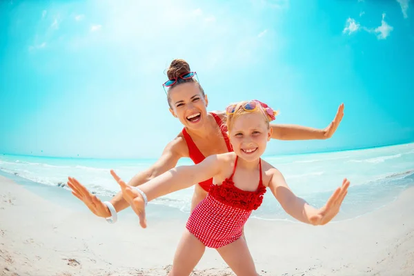 Glückliche junge Mutter und Tochter am Meeresufer haben Spaß — Stockfoto