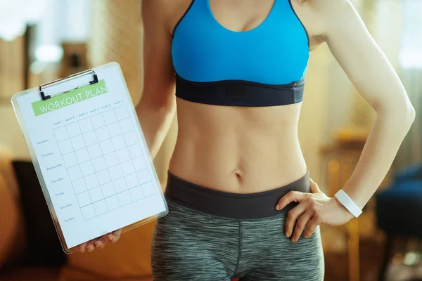 Close-up em mulher de esportes em forma na casa moderna mostrando plano de refeição — Fotografia de Stock