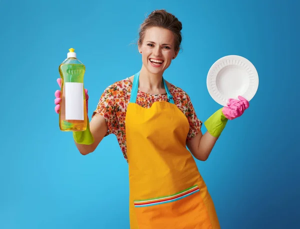 Heureuse femme au foyer avec plaque lavée montrant liquide vaisselle — Photo