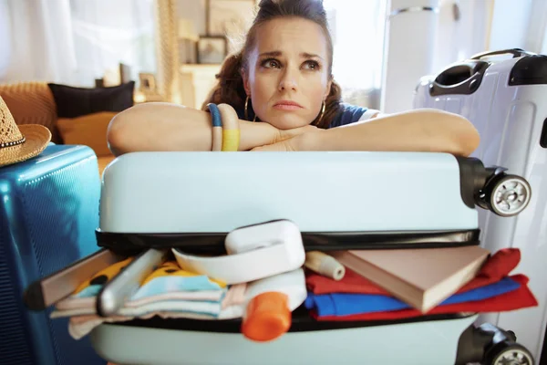 Unhappy stylish woman relaxing on over packed suitcase — Stock Photo, Image