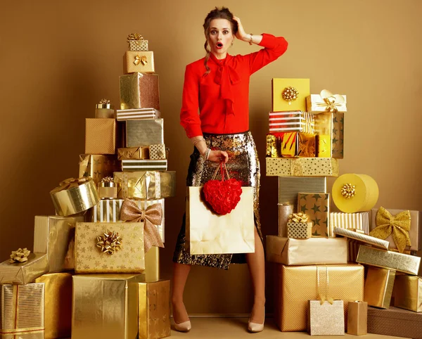 Scioccato giovane donna con shopping bag e cuore rosso — Foto Stock