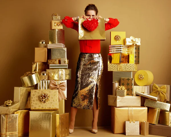 Elegant shopper kvinna gömmer sig bakom shoppingväska och rött hjärta — Stockfoto