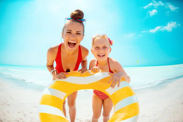Счастливые мать и дочь держат желтый надувной спасательный круг — стоковое фото