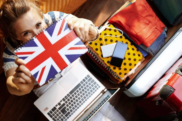 Vrouw toont Groot-Brittannië vlag notebook tijdens het boeken van Hotel op — Stockfoto