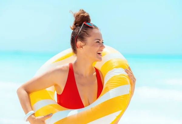 Woman looking into the distance wearing yellow inflatable lifebu — Stock Photo, Image