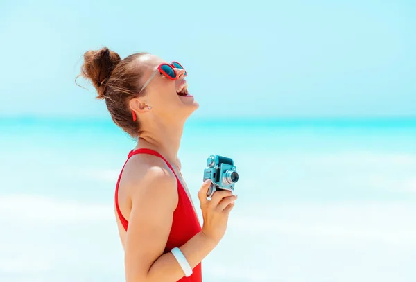 Mulher moderna feliz com câmera de foto retro no litoral — Fotografia de Stock