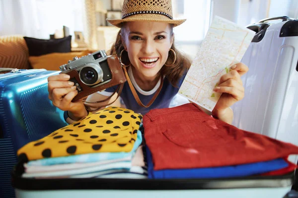 Женщина с ретро-фотокамерой и упаковкой карт для путешествий — стоковое фото