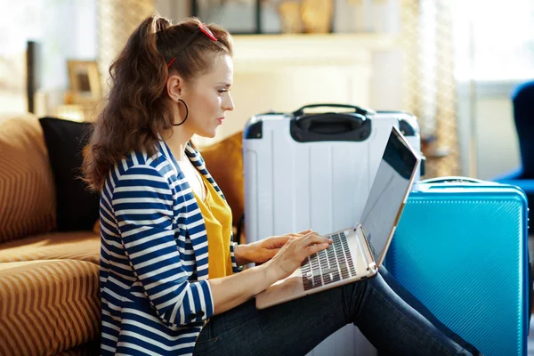 Trendy vrouw die vluchten online reserveert op laptop — Stockfoto