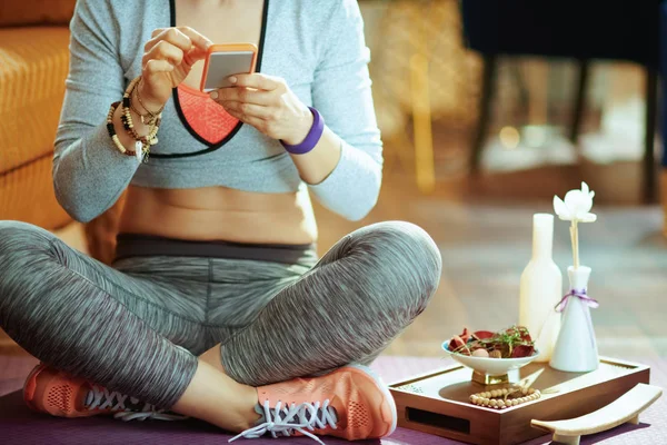 Nahaufnahme einer Frau mit persönlicher Yoga-Trainer-App im Smartphone — Stockfoto