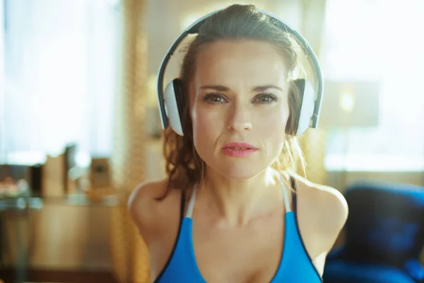Nainen kuuntelee musiikkia kuulokkeilla ja venyttely — kuvapankkivalokuva