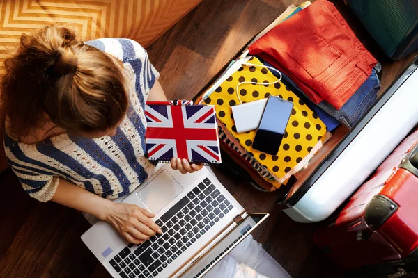 Mujer con la bandera de Gran Bretaña notebook comprar billete de avión — Foto de Stock