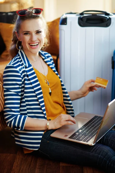 smiling modern woman with credit card booking tickets