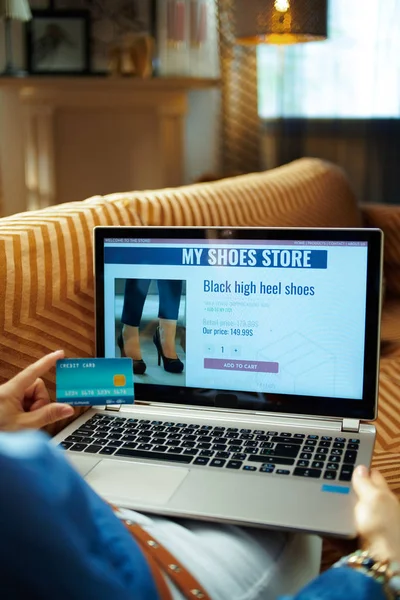 ノートパソコンでオンラインで靴を買うクレジットカードを持つ主婦 — ストック写真