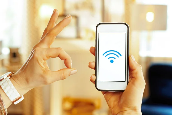 Крупный план на смартфоне с сильным Wi-Fi сигналом в руке женщины — стоковое фото