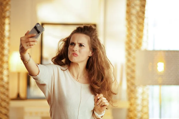 Besorgte Hausfrau fängt schwaches WLAN-Signal auf Smartphone auf — Stockfoto