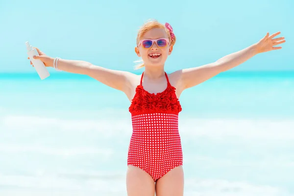 Sorridente ragazza moderna con crema solare gioire sulla costa — Foto Stock