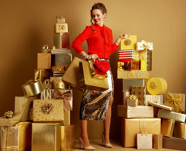 Gelukkige moderne vrouw met boodschappentassen en rood hart — Stockfoto
