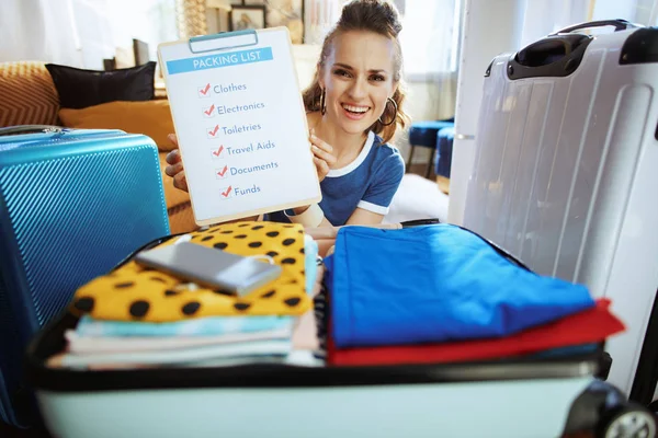 Happy young traveller woman showing packing list — Stock Photo, Image