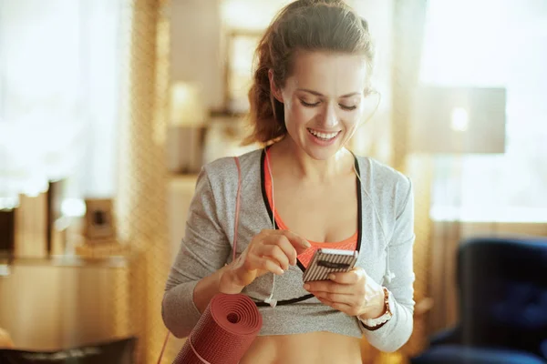 Sportvrouw die smartphone gebruikt om trainingsresultaten te delen — Stockfoto