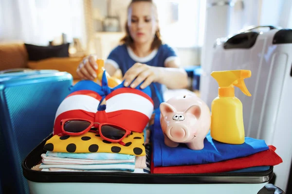 On tourist woman with piggy bank calculates summer budget — Stock Photo, Image
